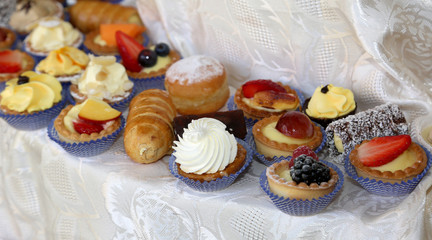 Wedding reception dessert with pastries made with cream and frui