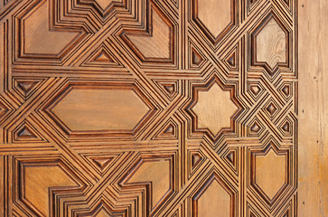 Old Arabic wooden door carved with Islamic style in the Alhambra Palace of Granada, Andalusia, Spain