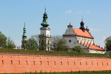 Obraz premium Towers of Town Hall and churches behind the walls and bastions of old fortress in Zamosc, Eastern Poland