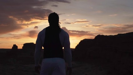 Fitness man overlooking beautiful desert valley at sunrise