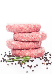 Raw fresh beef burgers with pepper and rosemarine