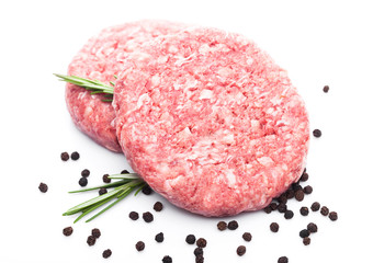 Raw fresh beef burgers with pepper and rosemarine