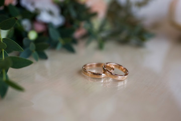 Obraz na płótnie Canvas wedding rings lie near beautiful bouquet as bridal accessories
