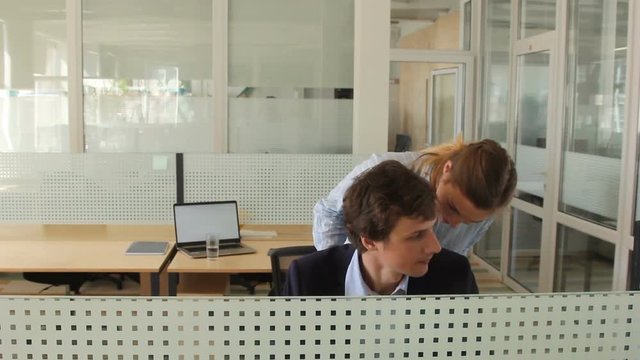 Crop view of attractive female flirting with smiling man in office