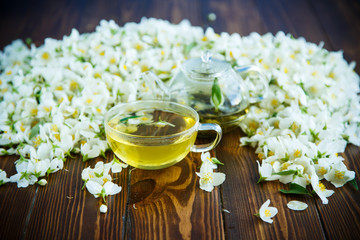Fototapeta na wymiar Tea with jasmine flowers in a glass teapot