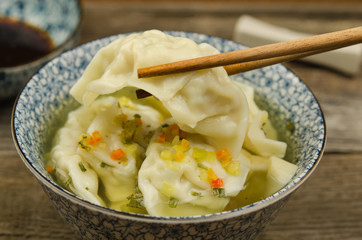 Dumpling soup with soy sauce. Fresh wonton soup and soy sauce with chopsticks. 
