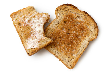 Half eaten buttered slice of whole wheat toast and whole dry slice of toast isolated on white from above.