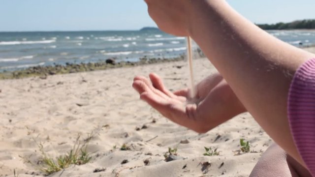 beach sand flows through hands