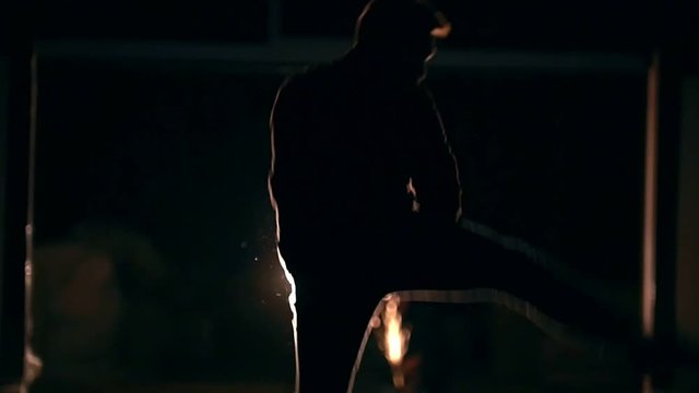 Night tricking, man jumps and makes a kick in the air with his foot