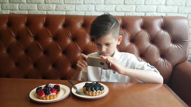 Young kid make food foto in cafe with smartphone