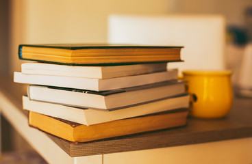 Book stacking. yellow mag near. Hardback books on wooden table. Back to school. Copy space for text. Education background.