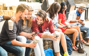 Multiracial millennials group using smart phone at city college backyard - Young people addicted by mobile smartphone - Technology concept with connected trendy friends - Warm vibrance sunshine filter