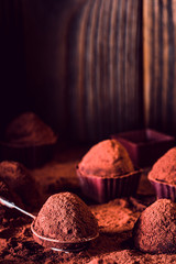 Chocolate truffles on wooden background, macro. delicious homemade truffle with dark chocolate and cocoa powder. Gourmet candies made by chocolatier dipping tool. Sweet dessert. Chocolaterie border