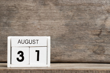 White block calendar present date 31 and month August on wood background