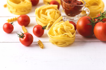 Pasta Products with Tomato Cheese Raw Pasta Fusili Fettuccine Ingredients Italian Food White Background Close Up