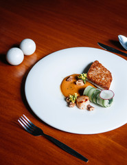 Seabass and Scallop steak modern cuisine, grilled seabass and Scallop with cream sauce on white plate on wood table