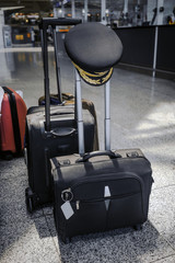 pilot cap hanging on handle of suitcase at airport © GoSlow