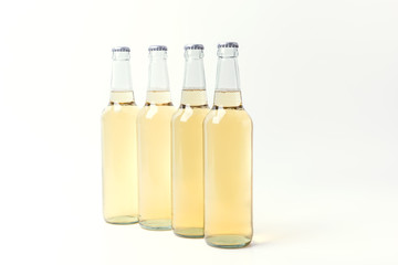 Four yellow bottles of beer on white background. 