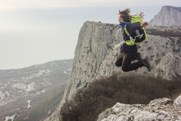 Obraz premium man jumping on a cliff in mountains