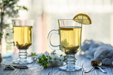 Fresh green tea. Tea cup with green tea leaf on the wooden table. Tea with lemon