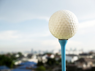Golf Ball on T Background city view