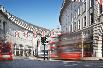 London, Regent Street with Jack Union flags and red buses.