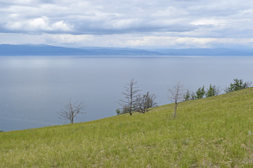 Blue lake Baikal from the green slope of the island.
