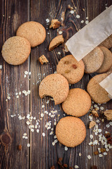 Homemade oatmeal cookies with raisins, cinnamon with milk on dark wooden background.