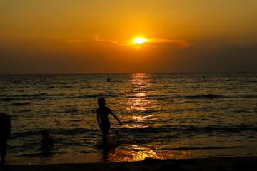 silhouette woman run from sea to beach and sunset