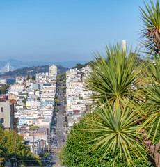 Lombard Street and Russian Hill with San Francisco city skyline on a sunny summer day