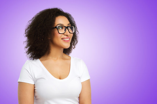 vision, body positive and people concept - happy smiling african american woman in white t-shirt and glasses over ultra violet background