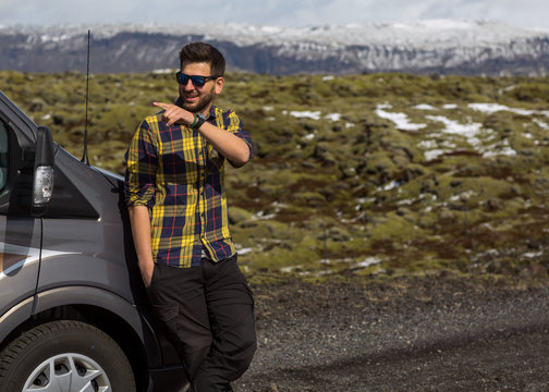 guy tourist driving a car in the mountains, traveling to Iceland.