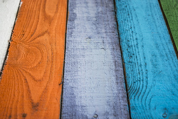 colorful background, colored green, white, orange, gray, brown paint of the old wooden planks for benches, fence