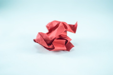 Red crumpled paper ball on the white background, isolated. Abstract concept of idea, innovation, creativity, imagination, success, and diversity.