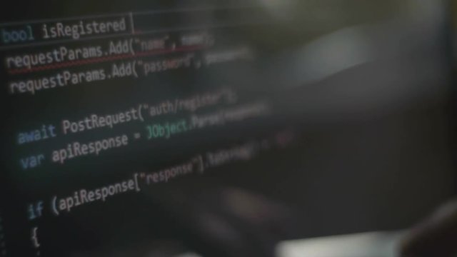 Reflection in the computer monitor of fingers typing on the keyboard