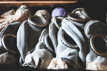 New gas masks laying in wooden box in the warehouse. Equipment used in cases of natural disasters, ecological catastrophes, armed conflicts, fires.