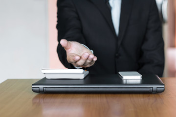 businessman hand and calculator and computer whit smartphone on office desk