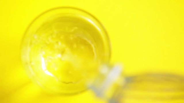versando acqua in un bicchiere con una bottiglia di plastica