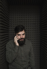 Man talking on the phone in an isolated booth