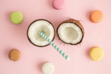 Fototapeta premium Coconut with macaron cookies against rose background abstract.
