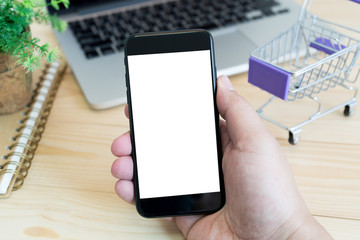 hands holding empty screen of smartphone on wood desk work.