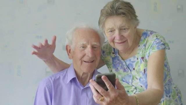 Elderly caucasian couple taking looking at a smartphone