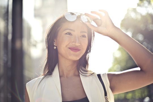 Smiling woman wearing elegant clothes and sunglasses