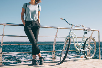 Stylish young woman standing at the background of blue sea