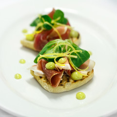 bruschetta with hamon and lime sauce and lettuce on the white plate