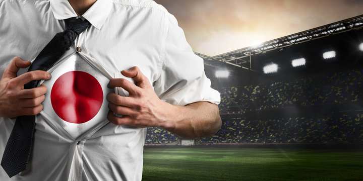 Japan soccer or football supporter showing flag under his business shirt on stadium.