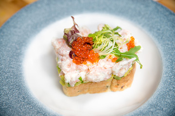 A delicious homemade shrimp sandwich with lettuce, tomato, tartar sauce and red caviar.
