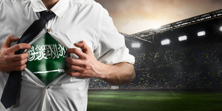 Saudi Arabia soccer or football supporter showing flag under his business shirt on stadium.