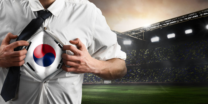 Korea soccer or football supporter showing flag under his business shirt on stadium.