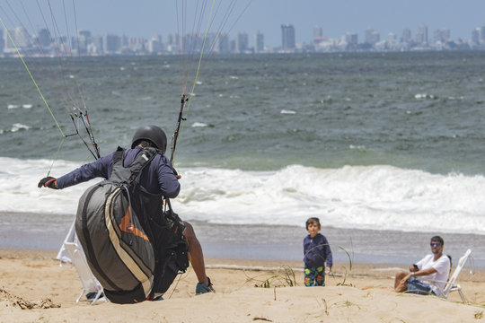 paracaidista aterriza en la playa gente sorprendida